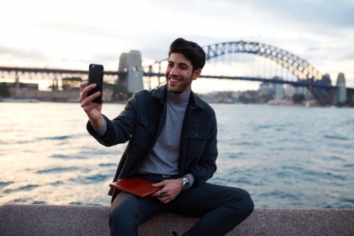 Tourist taking a selfie with the Sydney Harbour Bridge in background - Australian Stock Image