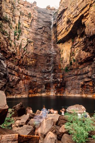 Tourists climbing the rocks at Jim Jim Falls, Kakadu National Park - Australian Stock Image