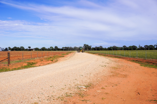 tractor driving down a lane way on a farm - Australian Stock Image