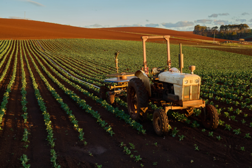 Tractor sits in the middle of a cultivated field - Australian Stock Image