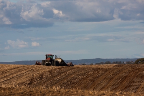 Tractors ploughing dirt in a dry paddock