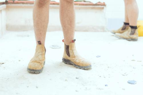 Tradesman wearing boots on construction site - Australian Stock Image