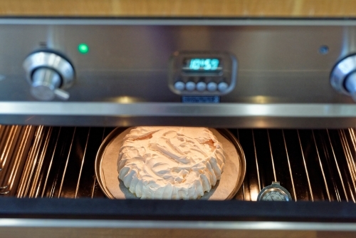 Traditional Australian Pavlova cooling in the oven - Australian Stock Image