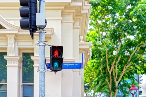 Traffic lights for pedestrian crossing, close up with old building behind - Australian Stock Image