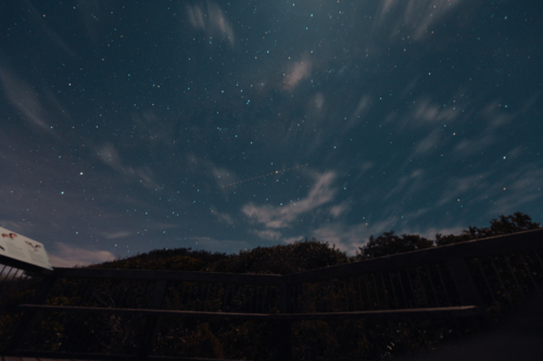 Trail of satellite passing through stars in the night sky - Australian Stock Image