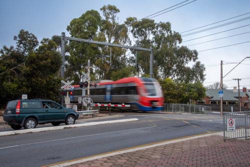 Train going across the road at a level crossing long exposure motion blur - Australian Stock Image