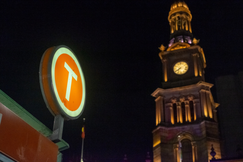 train sign with a lit up Sydney Town Hall on the background - Australian Stock Image