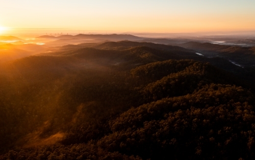 Tree-covered mountain landscape at sunset - Australian Stock Image