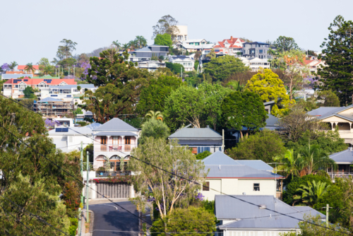 Treelined steep residential street climbing uphill viewed from elevated viewpoint - Australian Stock Image