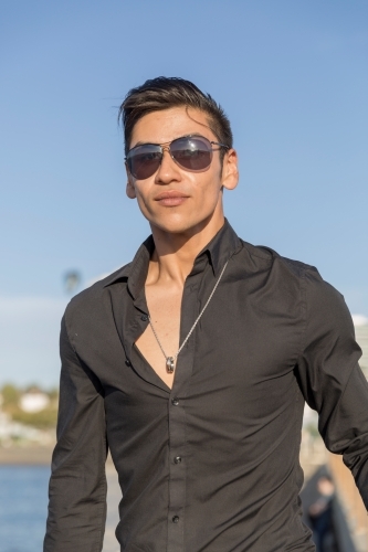 Trendy young latin man walking up stairs towards camera - Australian Stock Image
