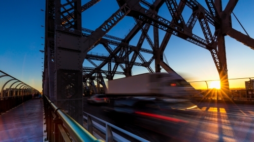 Truck motion blur on bridge with sun star in Brisbane CBD - Australian Stock Image
