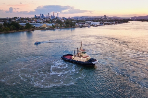 Tugboat ferry at sunrise on the Brisbane River with city views