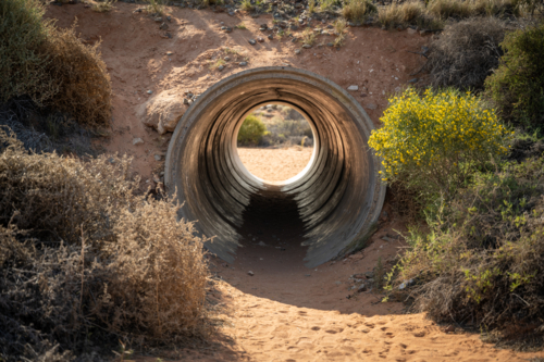 tunnel surrounded by bush and desert sand - Australian Stock Image