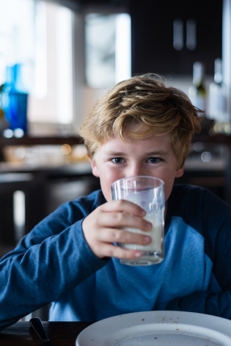 tween boy enjoying toast and milk for breakfast - Australian Stock Image