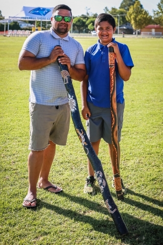Two aboriginal males standing holding didgeridoo