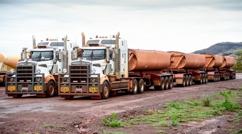 Two big road train trucks side by side on outback road