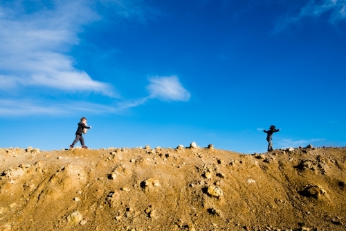 Two boys walking along a dam wall - Australian Stock Image