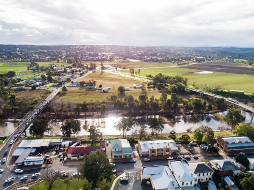 Two bridges across Hunter river in Singleton on sunlit day with town on one side - Australian Stock Image