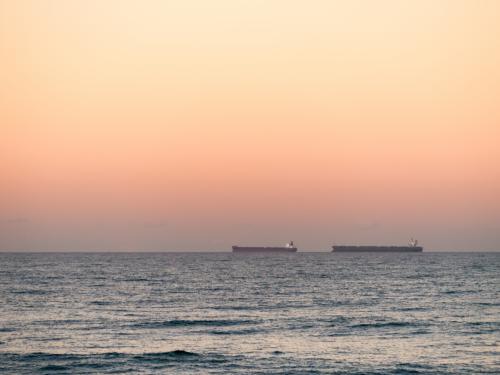Two bulk carriers (ships) on the horizon at dusk - Australian Stock Image