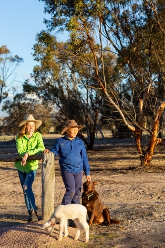 Two country kids with their kelpie dog and pet lamb - Australian Stock Image