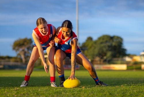 two female footballers going for the ball during training