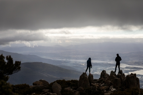 Two figures on a mountain top in the clouds - Australian Stock Image