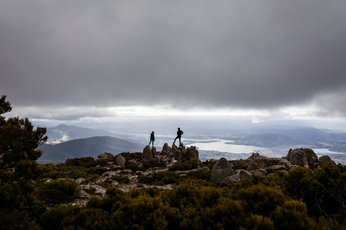 Two figures on a mountain top in the clouds - Australian Stock Image