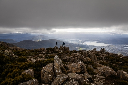 Two figures on a mountain top in the clouds - Australian Stock Image