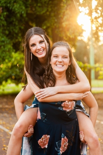 Two friends being silly together laughing in afternoon light - Australian Stock Image