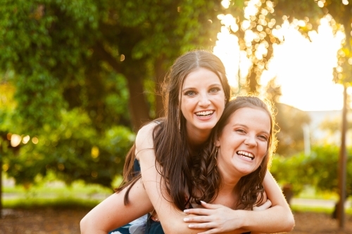 Two friends being silly together laughing in afternoon light - Australian Stock Image