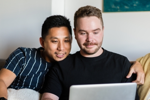 Two gay men using computer - Australian Stock Image