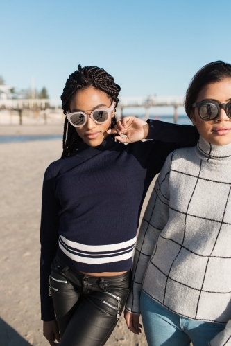 Two girl friends spending time on the beach together - Australian Stock Image