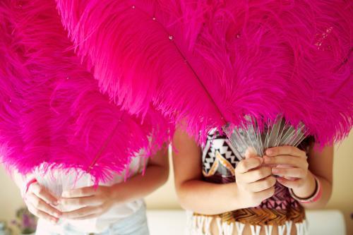 Two girls holding feather fans