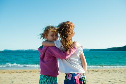 Two girls hugging a the beach