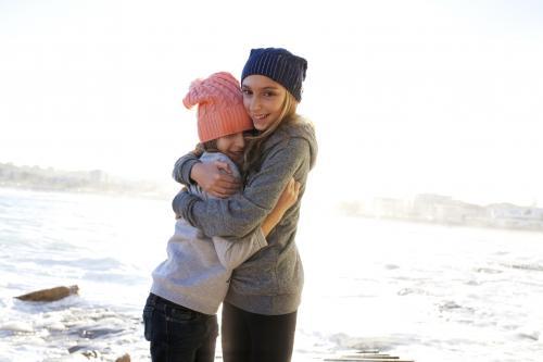 Two girls hugging by the ocean - Australian Stock Image