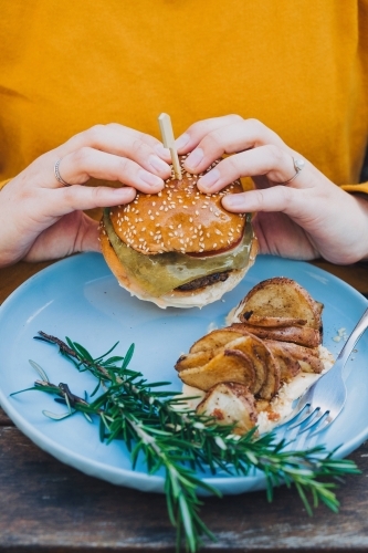 Two hands holding delicious hamburger - Australian Stock Image