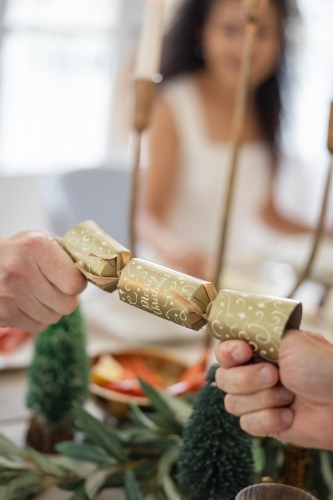 Two hands pulling at Christmas bon-bon - Australian Stock Image