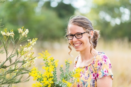 Two kinds of wattle blossoms and happy smiling woman - Australian Stock Image
