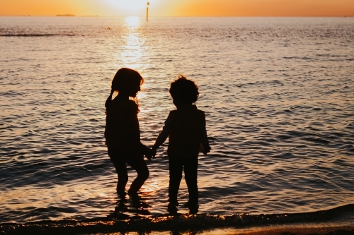 Two little girls silhouette at the beach