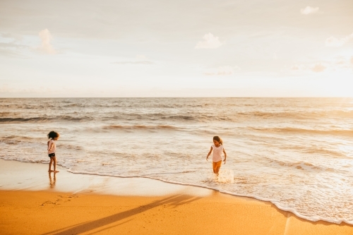 two little girls splashing at the beach - Australian Stock Image