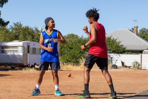 two mates play-fighting in vacant lot - Australian Stock Image