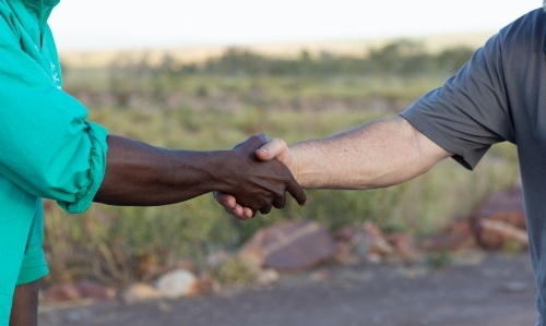 Two men shaking hands in the outback