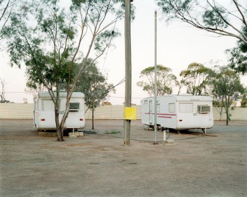 Two old caravans parked in dusty, remote caravan park - Australian Stock Image