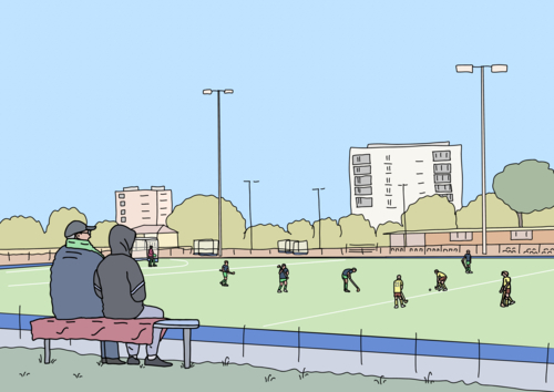 Two people rugged up to watch winter hockey game from sidelines - Australian Stock Image