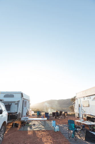 Two recreational vehicles parked on a dry, grassy field at campsite - Australian Stock Image