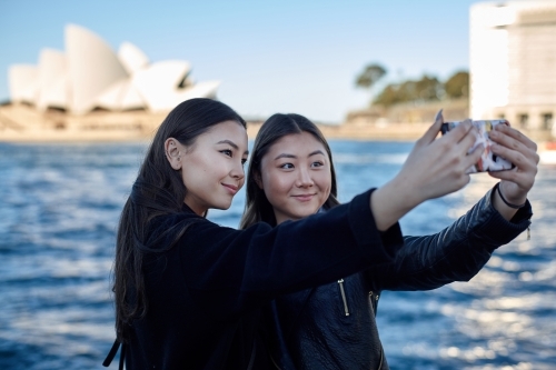 Two sisters spending time together harbourside taking selfie - Australian Stock Image