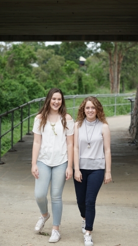 Two teenage girls walking on a paved pathway - Australian Stock Image