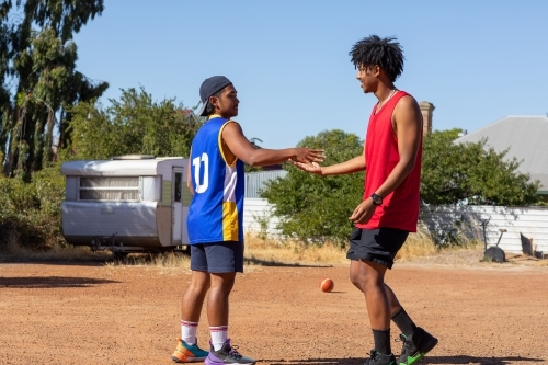 two teens doing their secret handshake outdoors