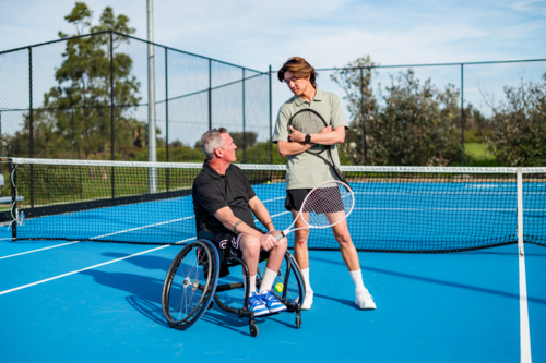 Two tennis players engage in practice on a blue court under a clear sky in Australia - Australian Stock Image
