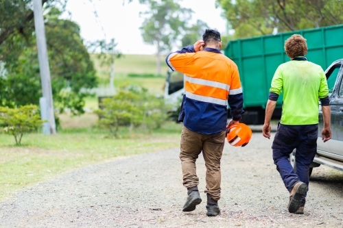 Two tradie blokes walking back to car after job is done